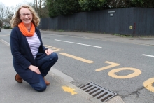 Councillor Karen Davies, Cabinet member for climate change and biodiversity, with one of the stencilled fish outside Oldfield Primary School in Bray Road.