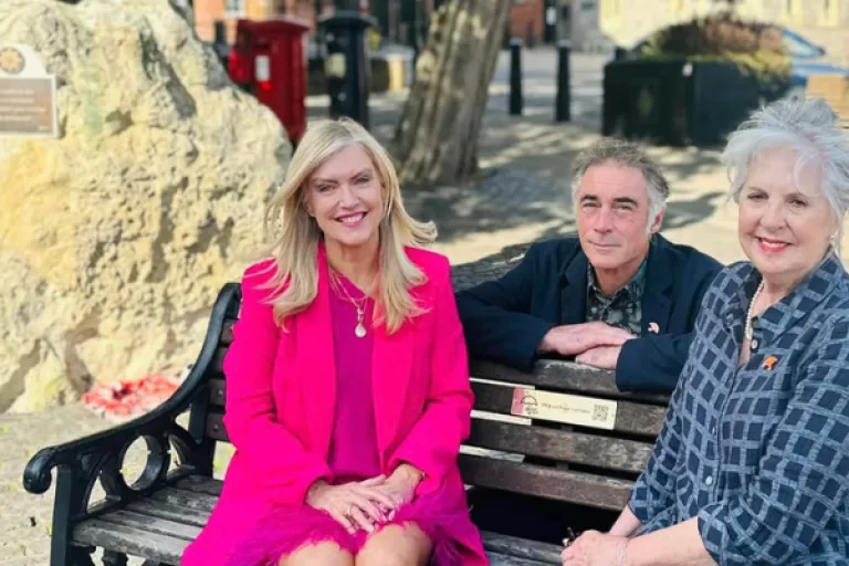 Founder of the Good Grief Trust Linda Magistris sits on a bench with the Trust's Patron Dame Penelope Wilton and Ambassador Greg Wise in Windsor