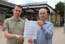 This image shows two councillors holding the letter of objection at Maidenhead Railway Station